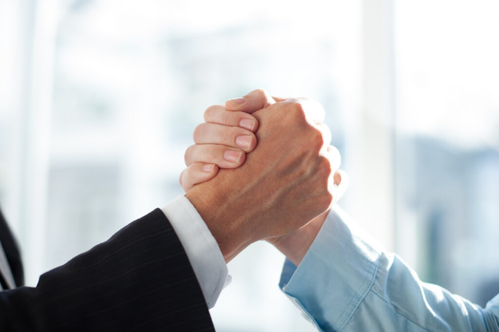Relacionamento com o Cliente - Duas pessoas dando um aperto de mãos